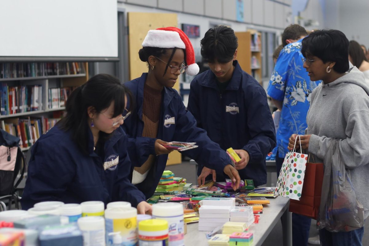 National Honors Society officers Christin Smith and Neil Roy help distribute the supplies. Along with regular school supplies, the clubs are also giving teachers gift cards.