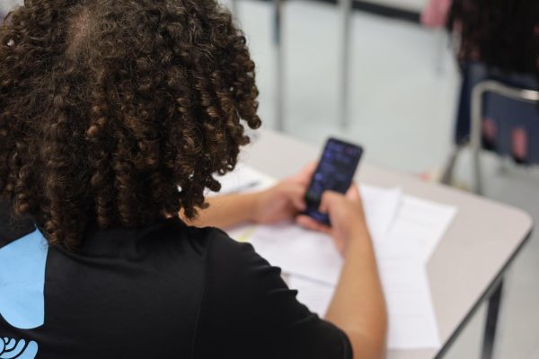 A student takes a break from classwork to text a friend. Cell phones are just one of the distractions that keep students from achieving high grades.