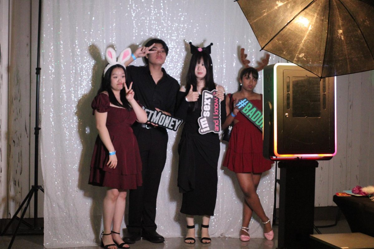 Seniors Riana Nguyen and Tyson Nguyen gather with friends at the photo booth. In addition to the photo booth, food and beverages were located outside the main ballroom.