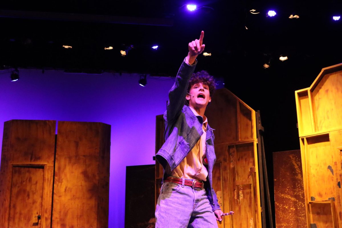 The Narrator calls to an audience member during a crowd-work section. He is played by senior Cole Jones, who tells the story of the puffs' time at their wizarding school.