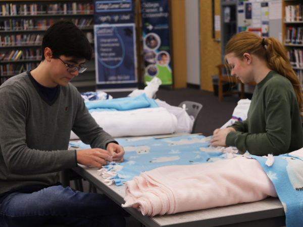 Senior Lauren Millikan and Aiden Gannon start tying the sides of their blanket. During their first service event NHS members were able to make a total of 28 blankets and wrote 46 letters. 