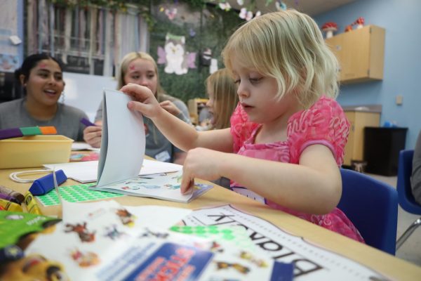 A Husky Pups Preschooler flips through a sticker book during the Spring Kids Night. This event took place on March 7 from 6-9 p.m.