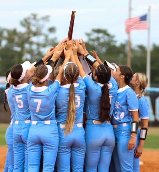 After a 2-0 victory over Timber Creek, the varsity softball team celebrates the district championship. 