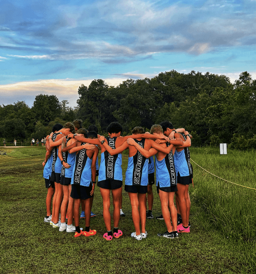 The boys cross-country team huddles before the race.