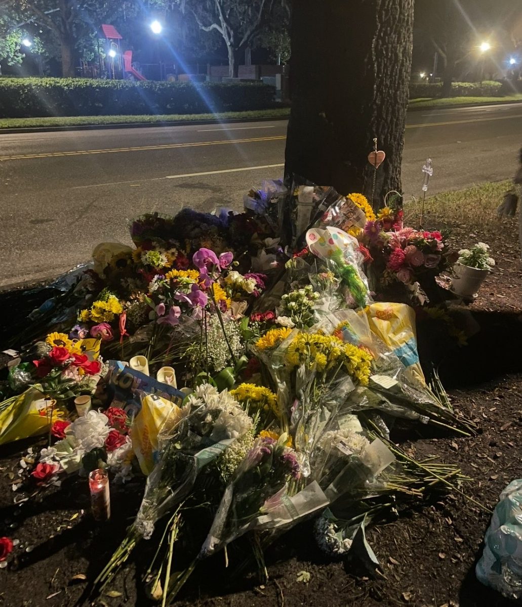 Flowers sit at the crash site on Alafaya Woods Blvd. from friends and family. A memorial was held on Aug. 30 where loved ones could pay tribute, and doves were released. Photo | Alyssa Duke