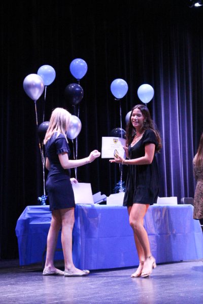 SNHS President Faith Walsh (12), inducts Emma Hill (11). Photo by Lucas Franco.
