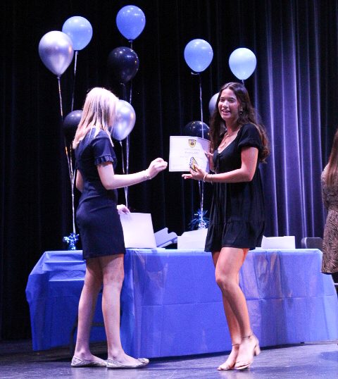 SNHS President Faith Walsh (12), inducts Emma Hill (11). Photo by Lucas Franco.