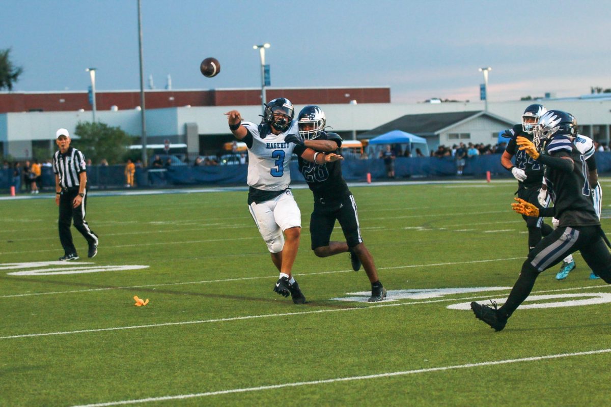 Junior quarterback Royce Jenkins throws the ball as he is being tackled. 