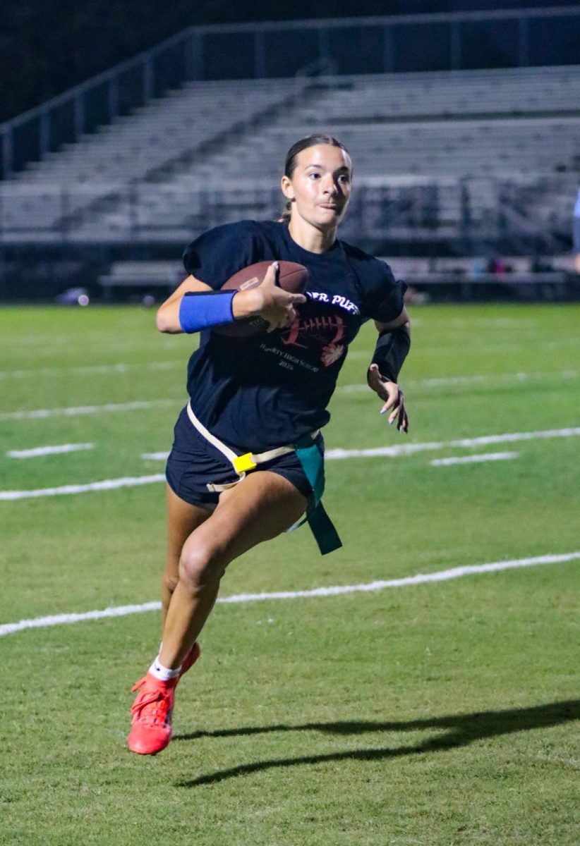 Securing the victory for the seniors, quarterback Courtney Dusart runs the ball to a first down. 