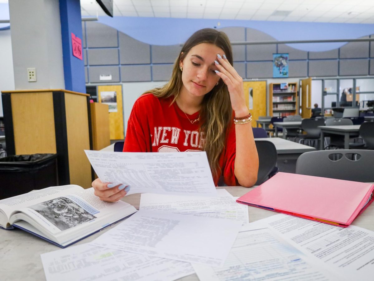 Senior Courtney Dusart reads her college transcript. She is one of the many students stressed about the college application process.