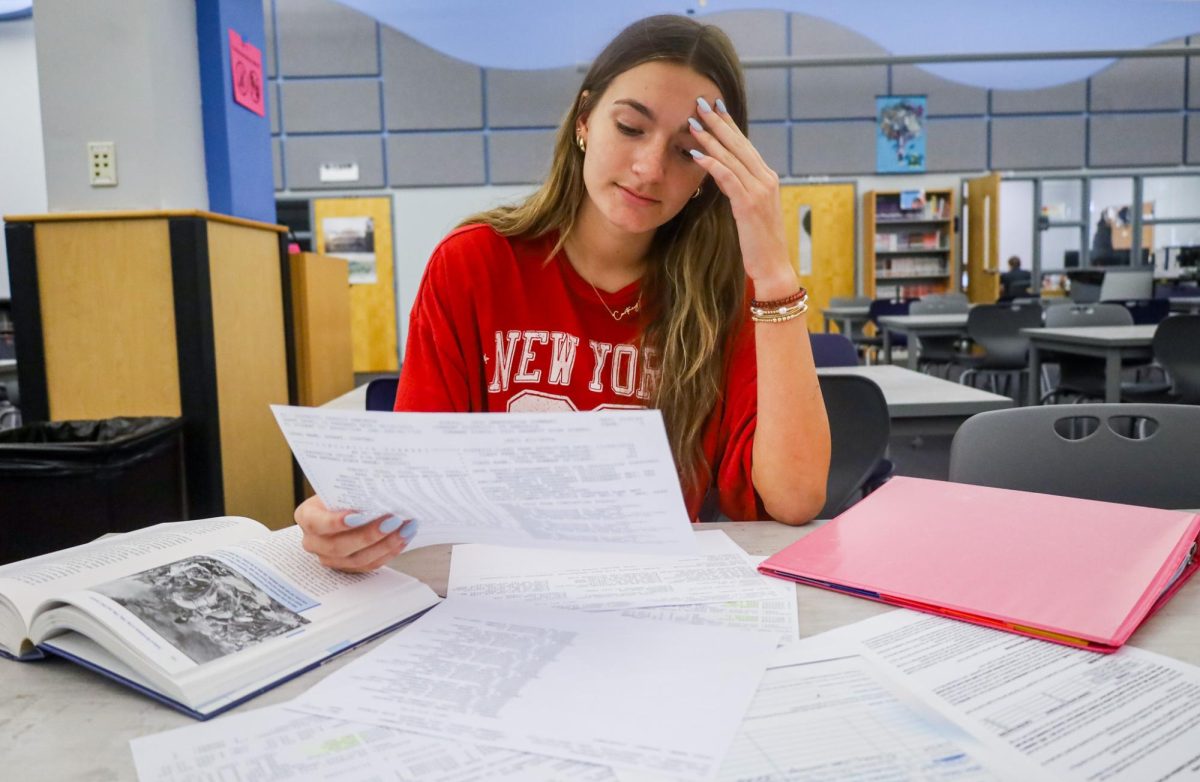 Senior Courtney Dusart reads her college transcript. She is one of the many students stressed about the college application process.