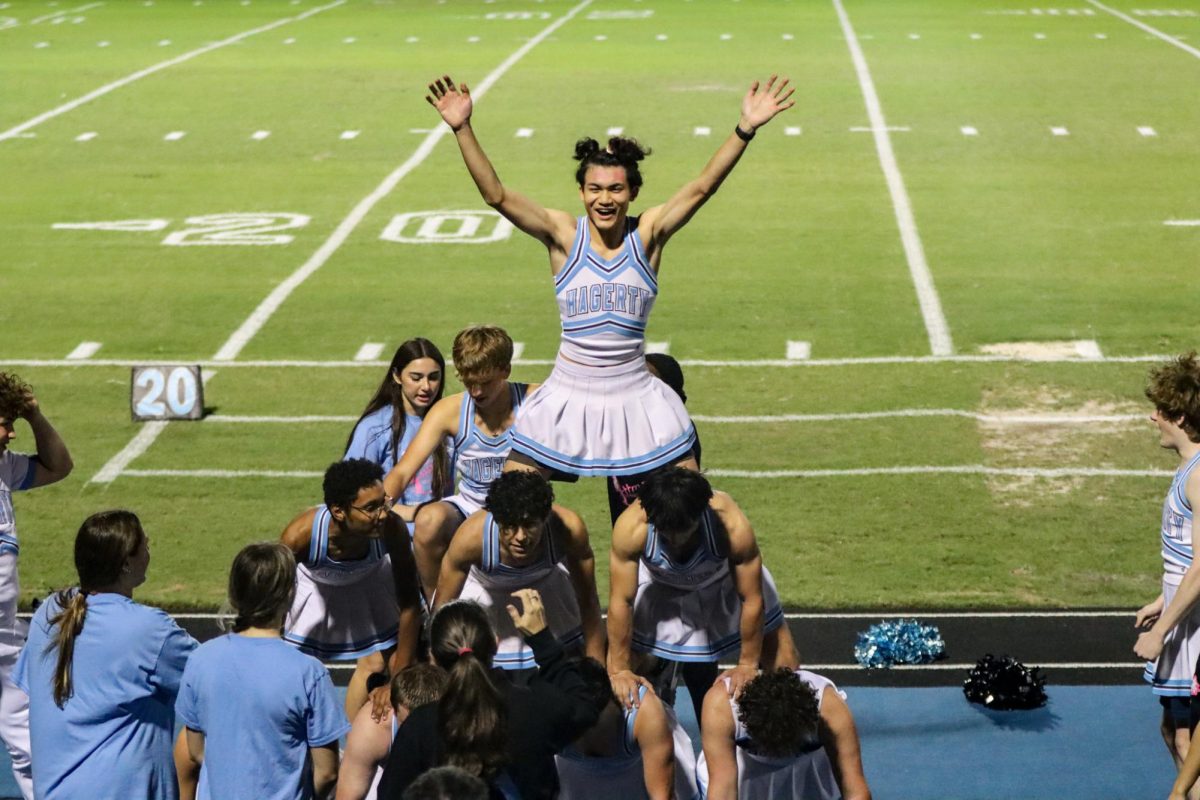 Building a three tier pyramid, Powderpuff cheerleaders successfully hoist Flyer Aiden Belcher way up above during their halftime routine. 