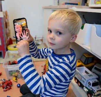 A toddler watches a TikTok on the best workouts for weight loss. Photo illustration | Isabella Ross