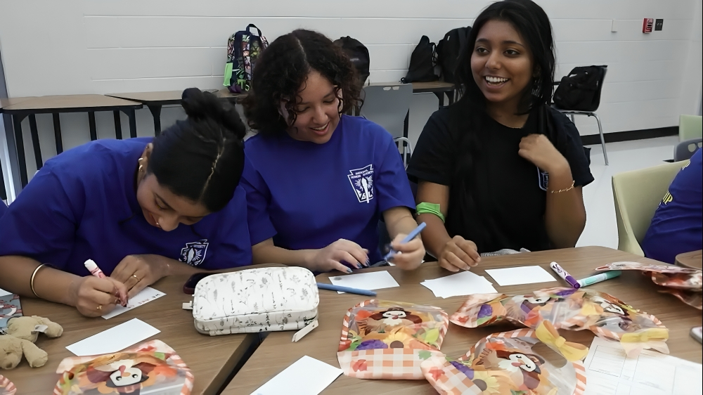 Seniors Samika Unnithan, Allyson Aquino and Adriana Antony write cards for the goody bags. The notes decorated with markers and stickers. 