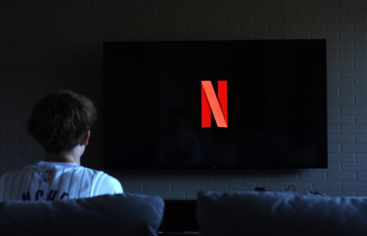 Senior Alex Zimmerman sits at home watching Netflix. The company is looking to acquire Warner Bros. studios and streaming.