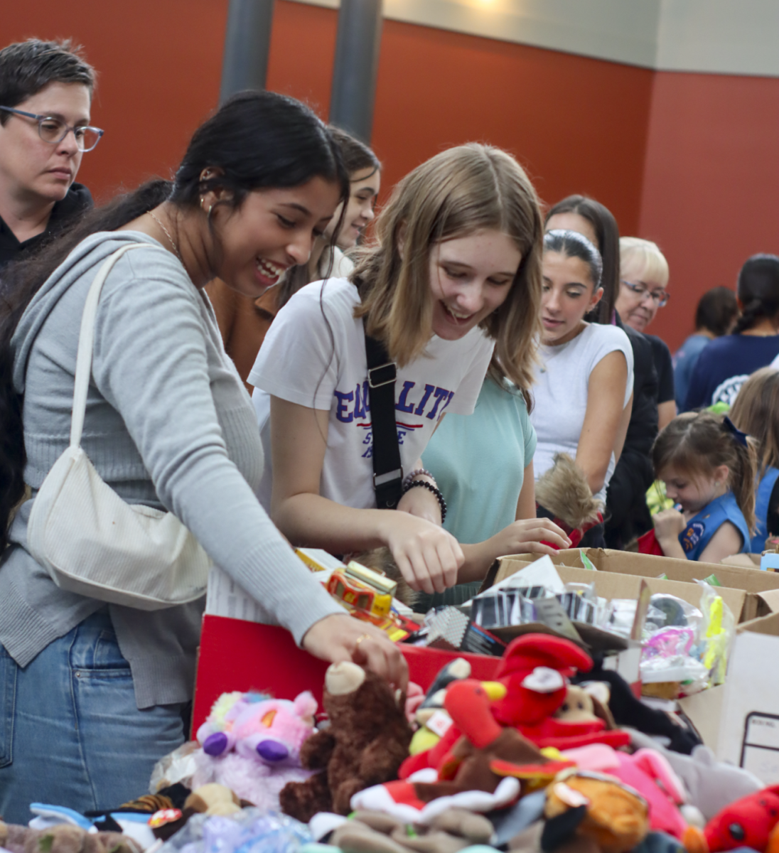 Students and community members are shown selecting items to include in stockings during a stocking stuffing event at the Oviedo Mall. Local children will receive the stockings by Christmas Day. 