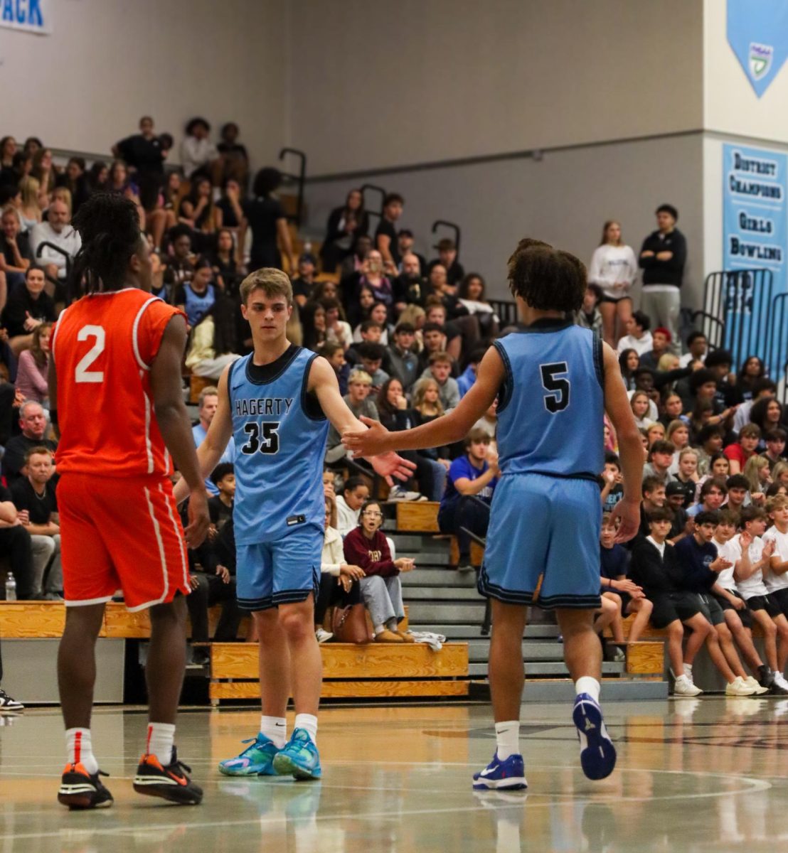 Seniors Asa Kohn and senior Jayden McCrae exchange a handshake. Between plays, the team has many unseen moments like these, helping bring them closer together. 
