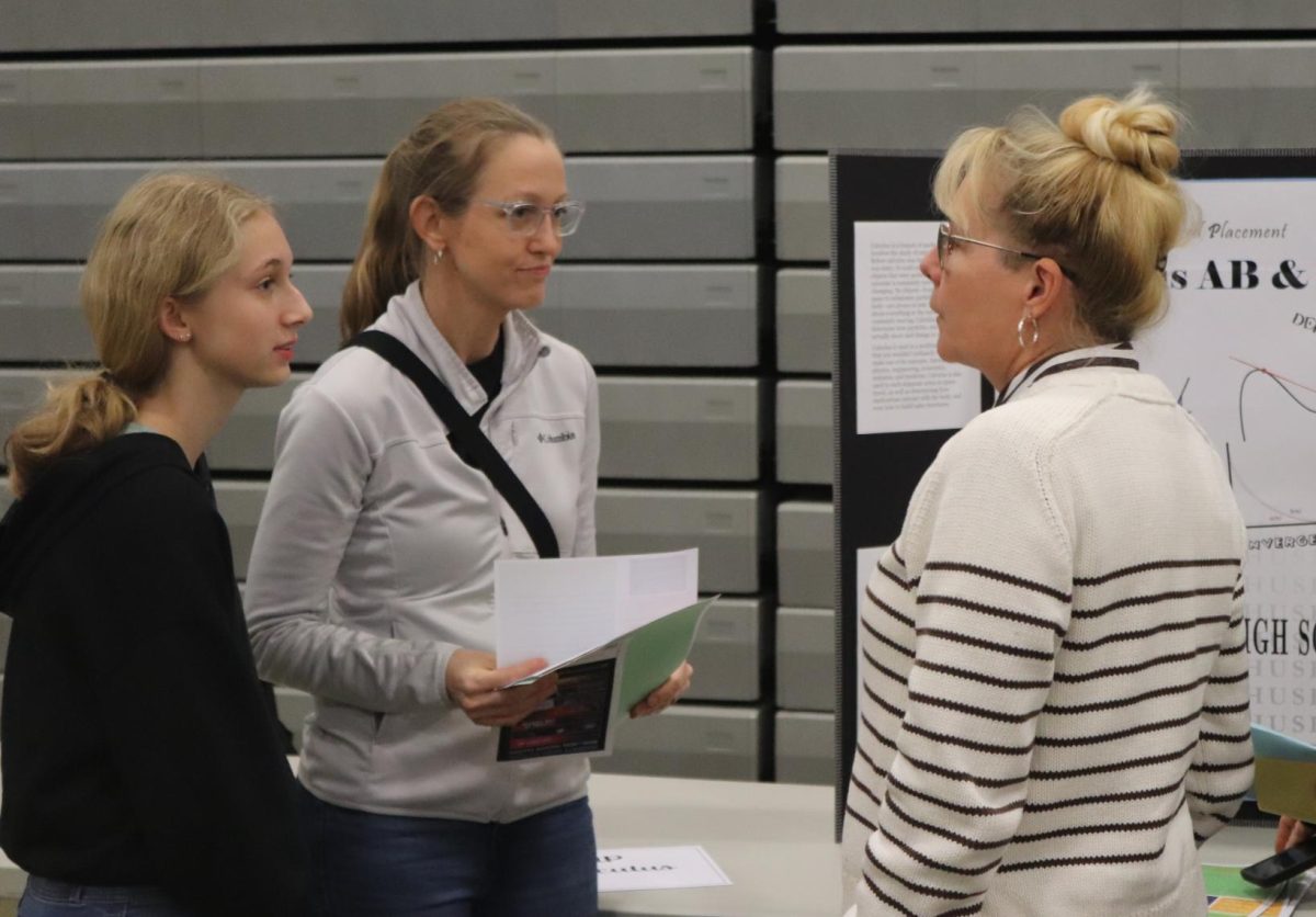 AP Calculus teacher Carolyn Guzman explaining the class to parents and students on Curriculum Night, at AP classes area.