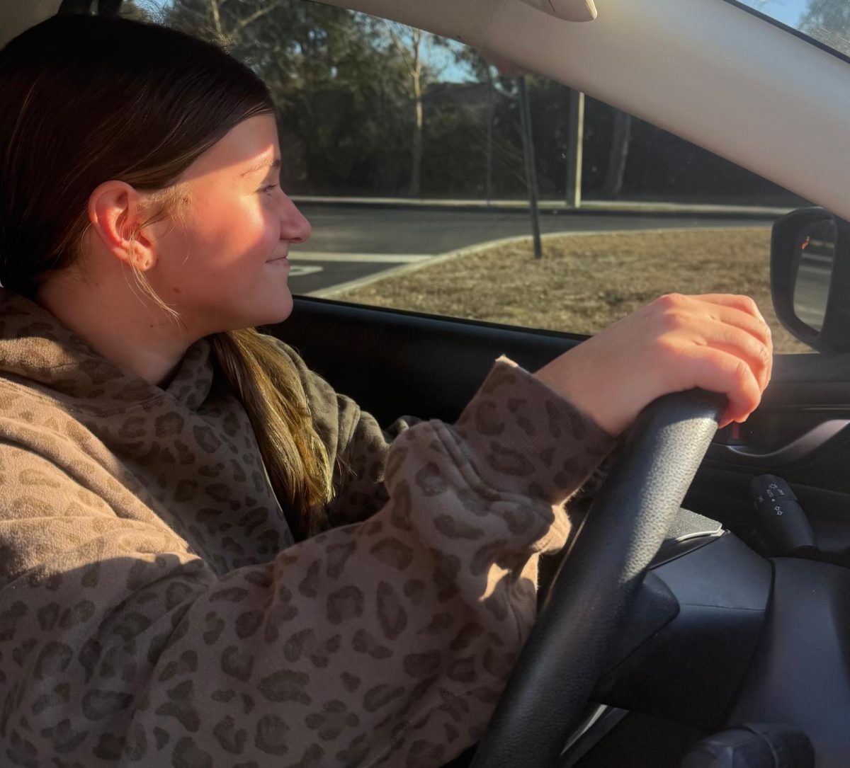 Senior Skylar Droste drives in the school parking lot. There are different colored parking lots, which are red and green.