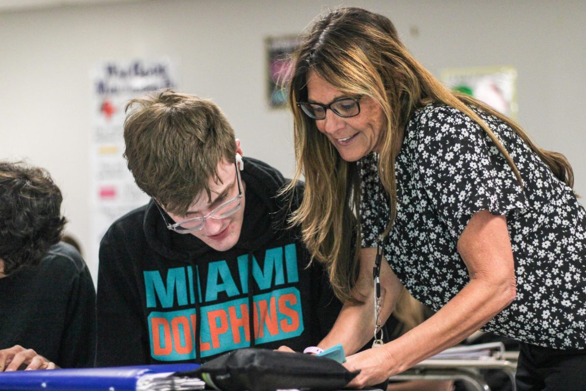 Long-term substitute Liz Maxwell works with senior Cole Matulis during midblock. Maxwell took over math classes for Brittany Brown at the beginning of the second semester and has had to work extra hours to learn the math well enough to teach her students.