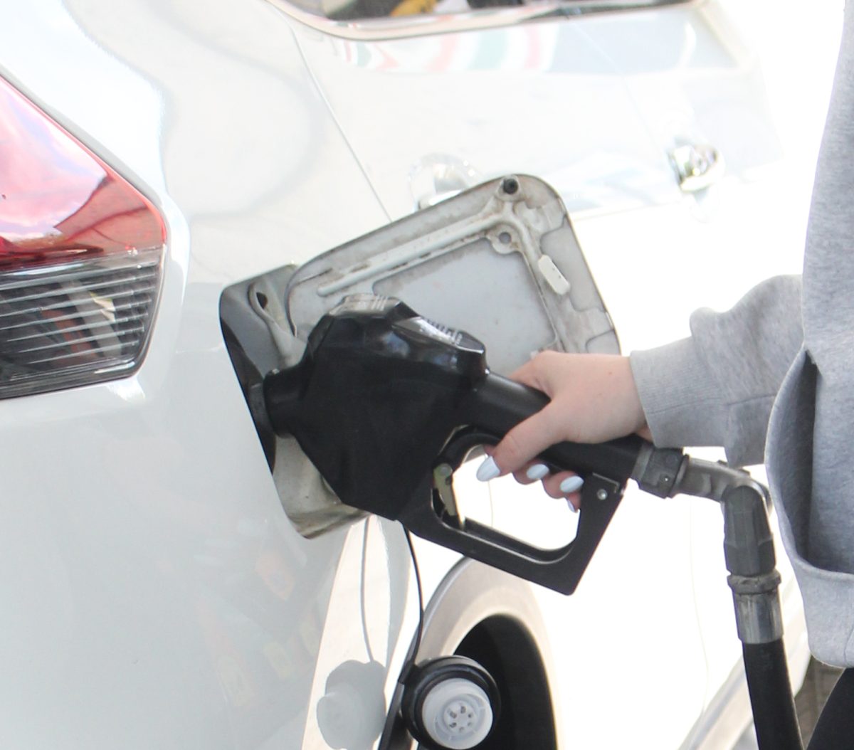 Junior Isabeau Benoit pumps gas into her car. Gas prices are expected to fluctuate as the war continues. (Photo by Carly Elassal)