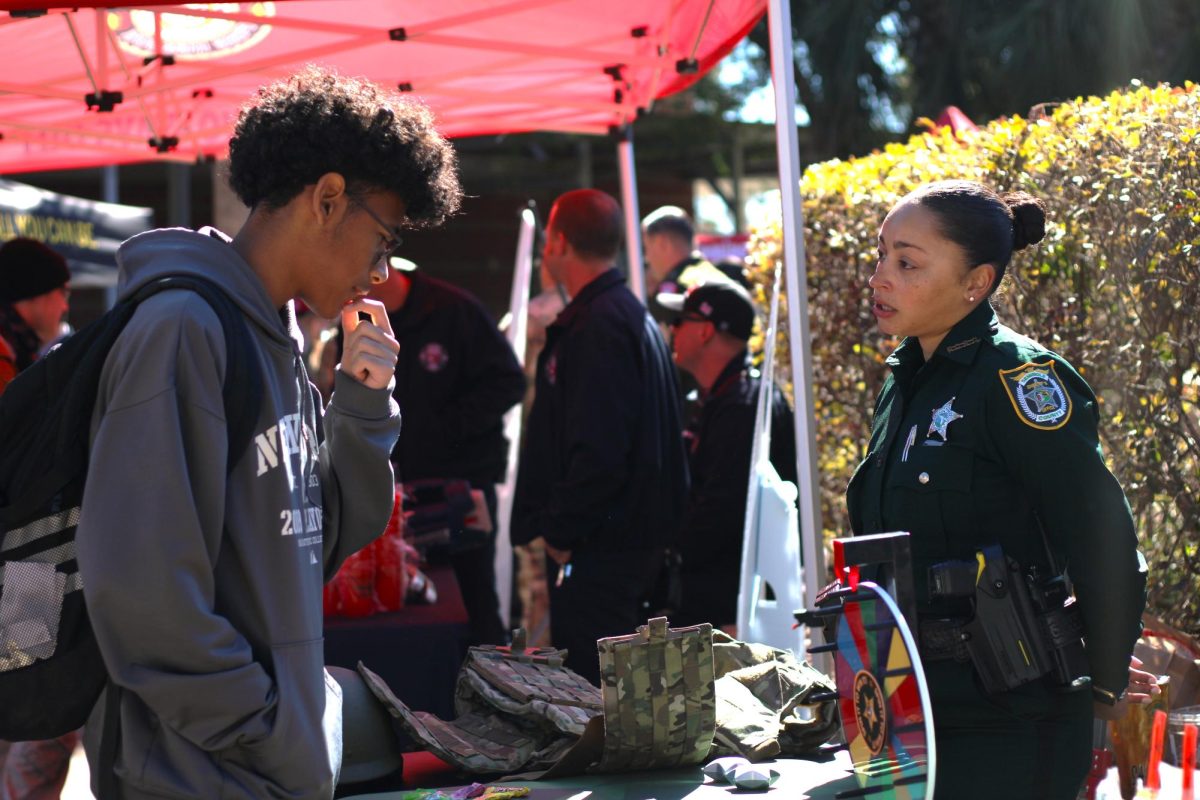 Freshman Kayden Vargas talks to a military recruiter at "Informed by the Uniform," an event aimed at allowing students to explore military options after school. The military is just one alternative options students may choose to pursue after graduation.