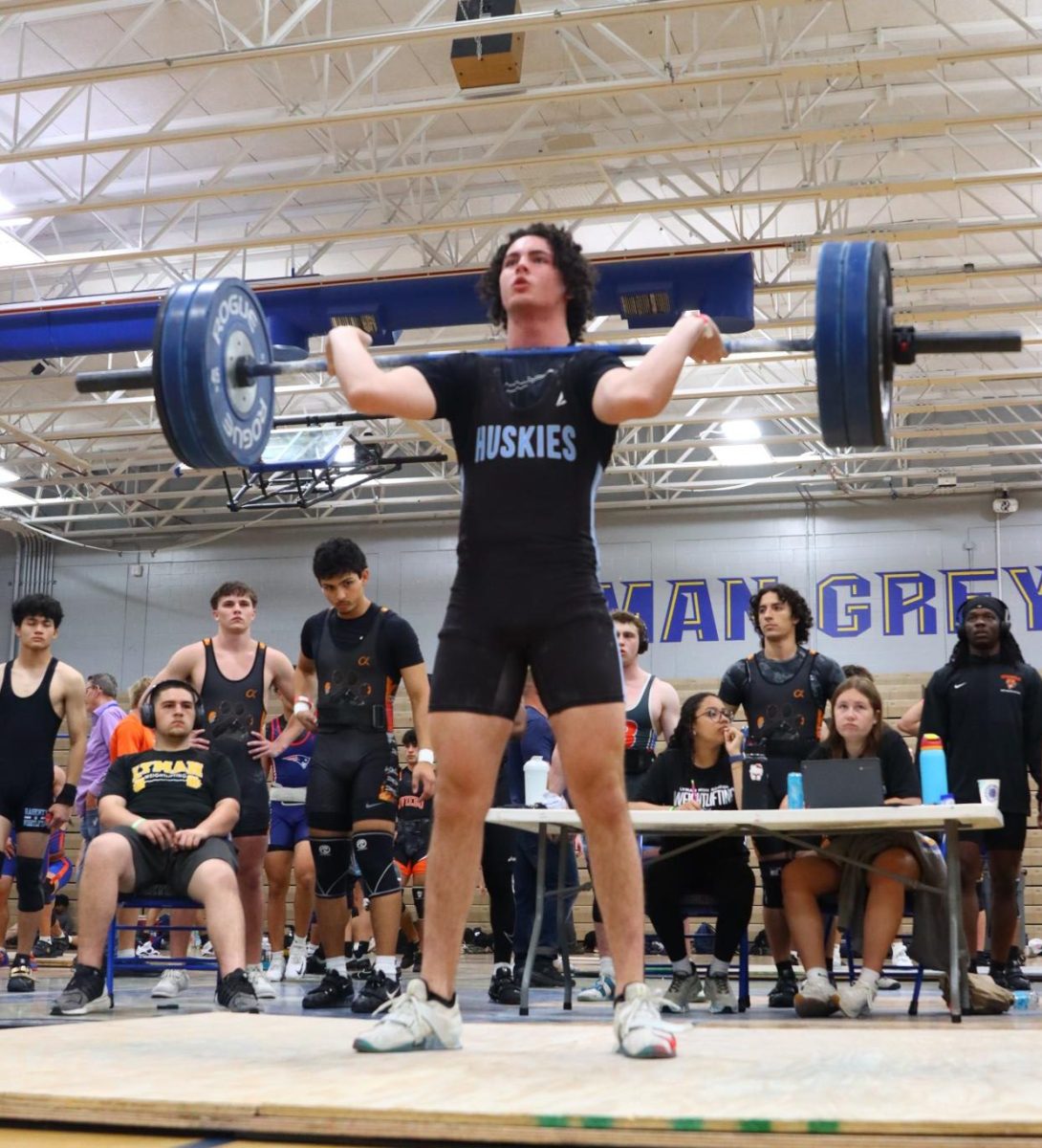 Junior Max Donovan performs the first movement of a clean and jerk. Donovan placed third in his weight class for Olympic weightlifting at the regional championships. Photo by Carla Grunner