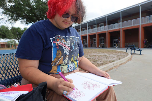 Senior Finch Uhing-Wagner sketches in a sketchbook. Because of AP 2D Art, he has confidence in pursuing art as a career.
