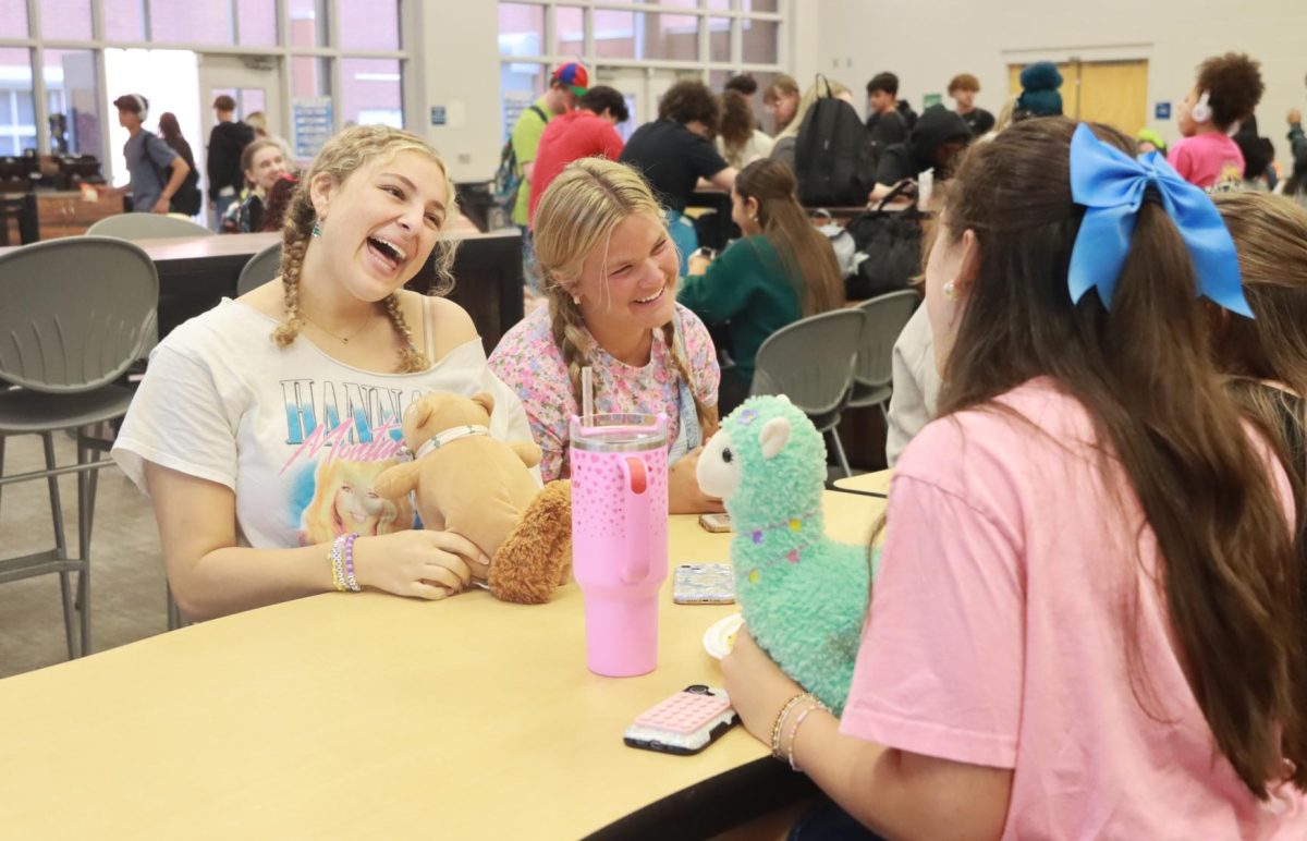 Seniors Laney Chamelin and Sarah Klopfenstein laugh with their friends during lunch. The two dressed up as their younger selves for the "10 years back" day on Tuesday.