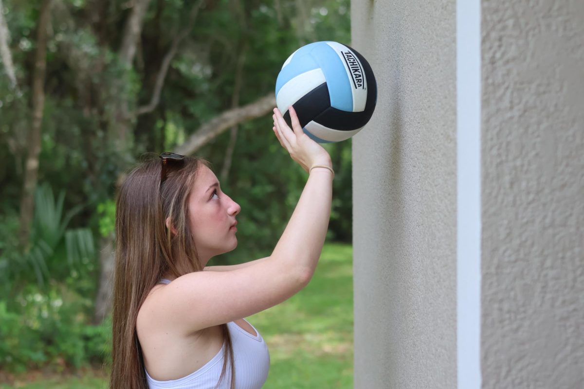 Freshman Zoe Spencer uses the wall at her house to practice setting for volleyball. Even at home, there are many ways to practice with some imagination. 